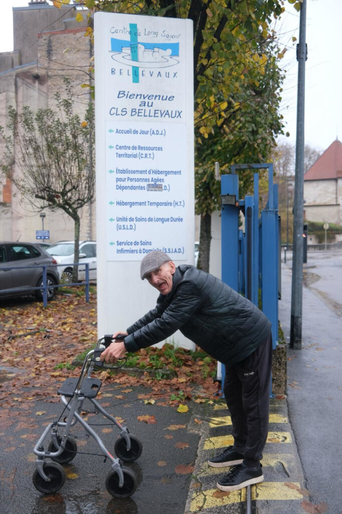 Personne agée en déambulateur devant sont établissement